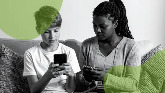 Två personer sitter i en soffa och tittar på sina telefoner.